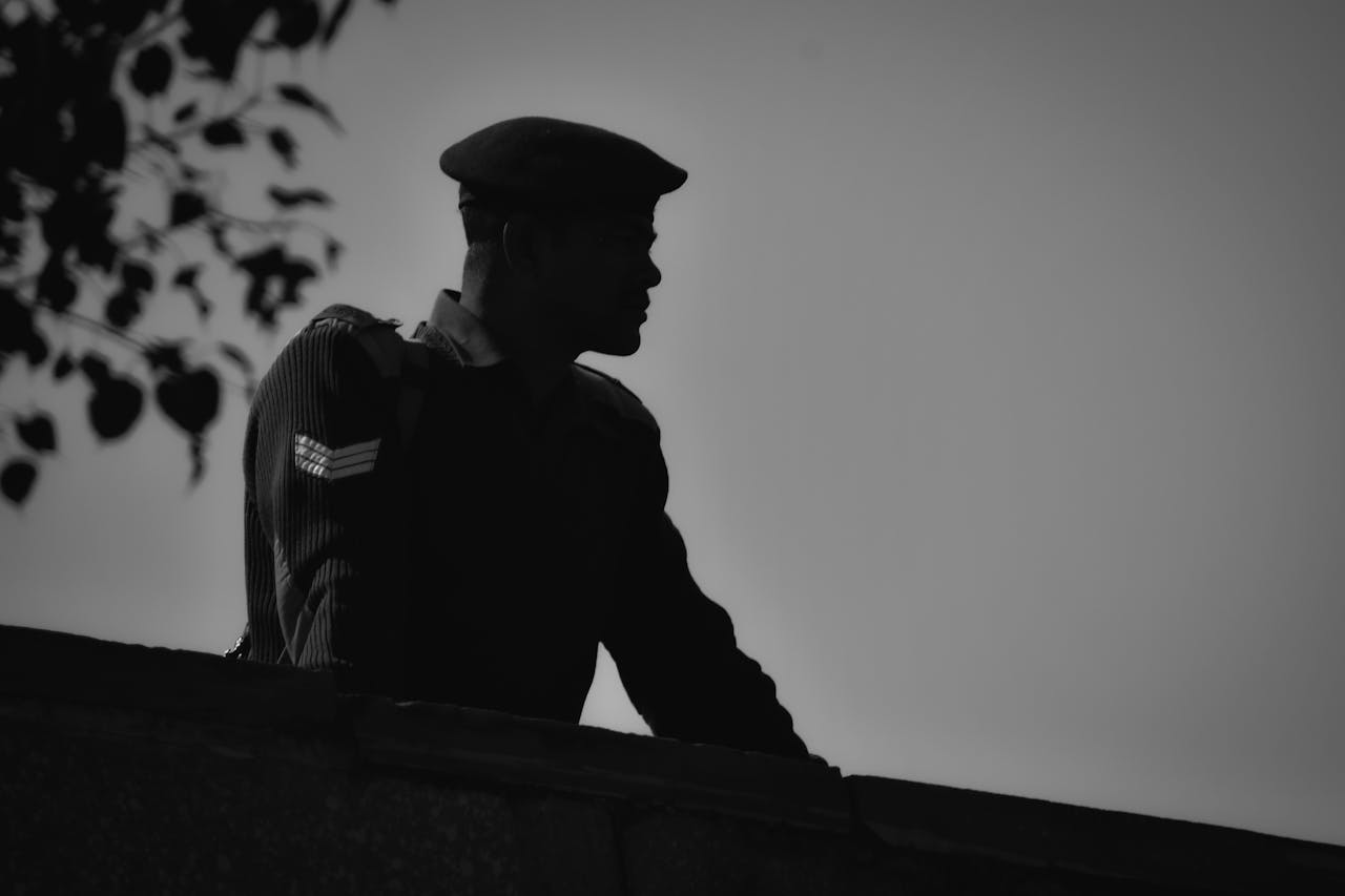 Black and white silhouette of a soldier in uniform against the sky in Agra, India.